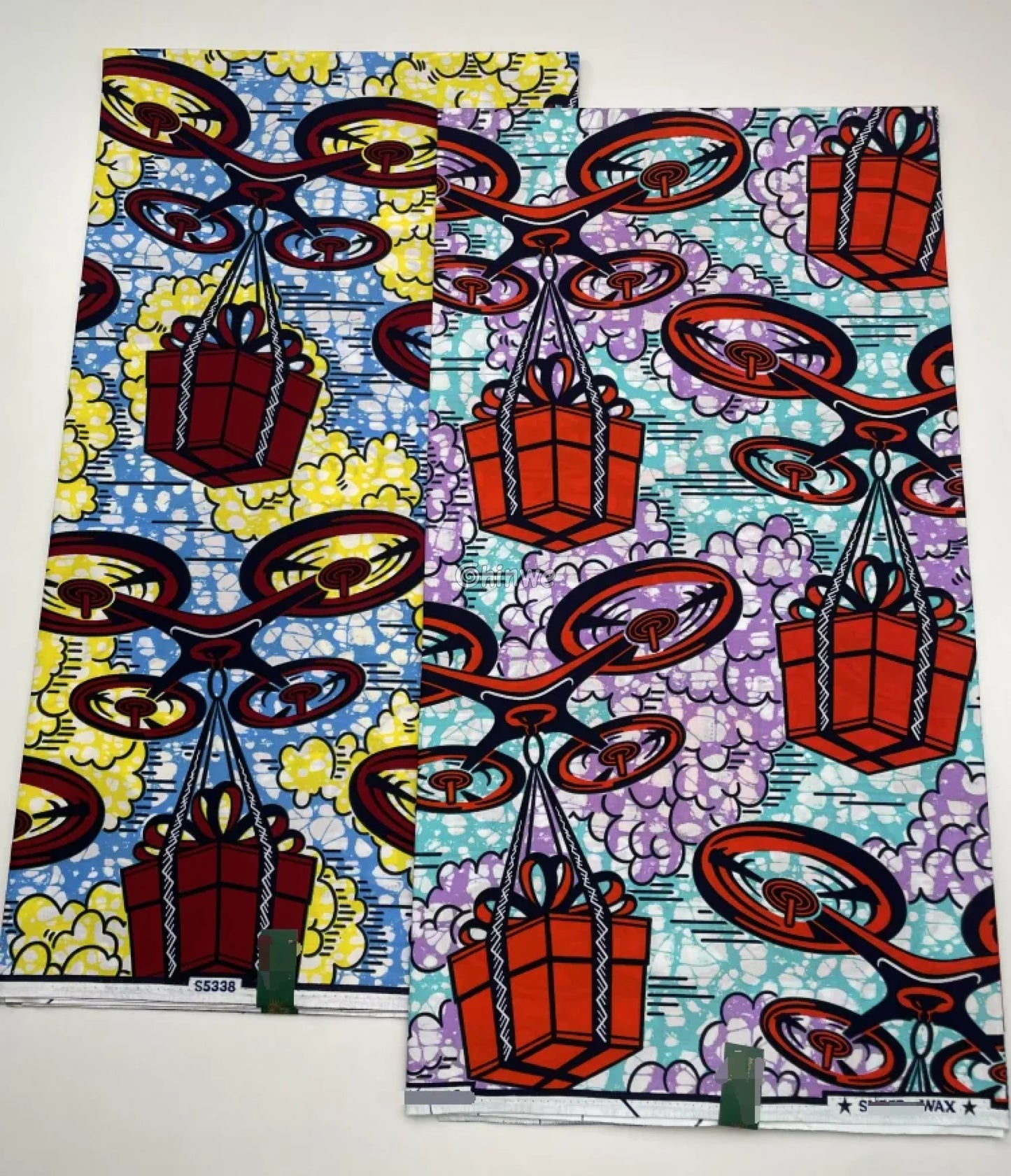 African Wax Print with Red Parcel Drones and Lilac Smoke on Sky Blue Batik Ground Tech-Inspired Motif Lavender Drone