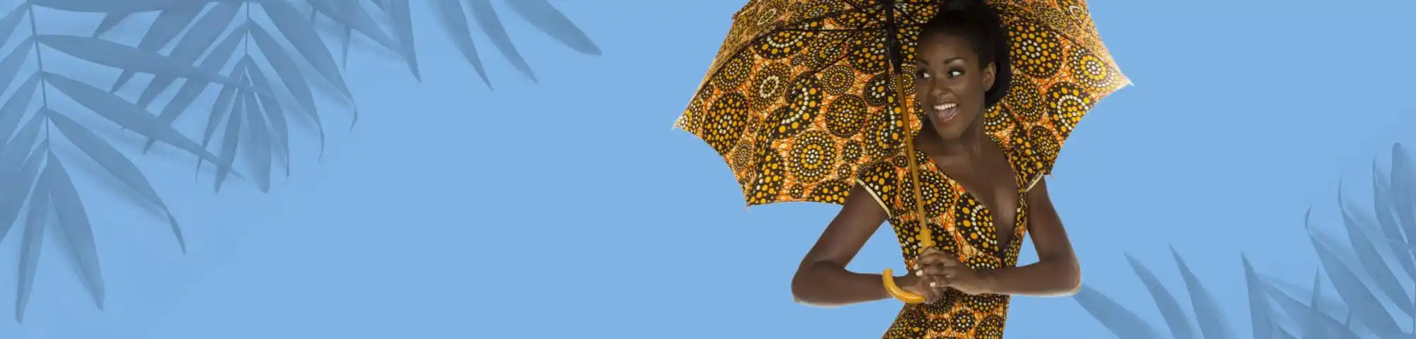 Woman holding a large decorative umbrella against a blue background with palm leaves. while wearing ankara african fabric