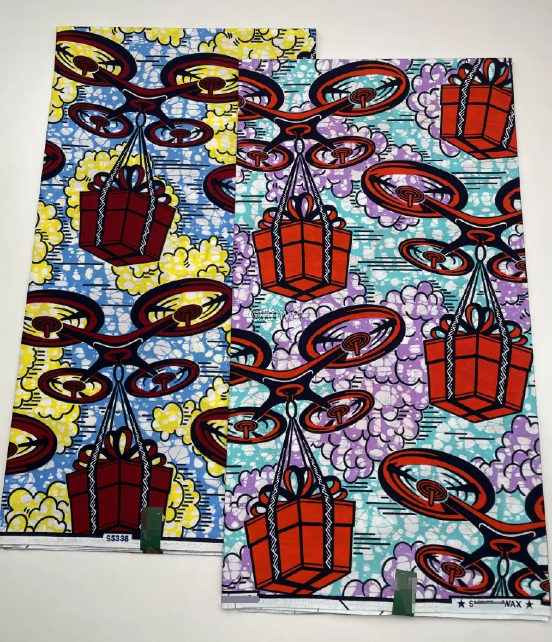 African Wax Print with Red Parcel Drones and Lilac Smoke on Sky Blue Batik Ground Tech-Inspired Motif Lavender Drone