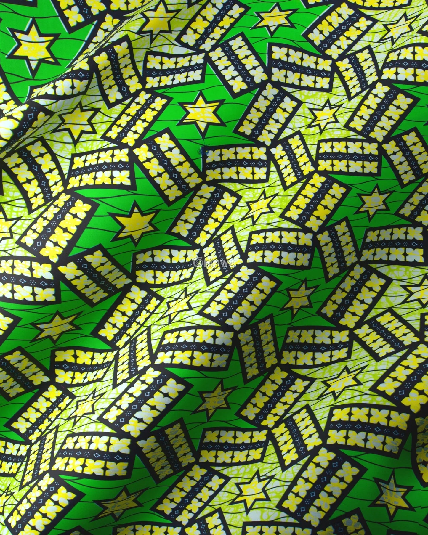 Patterned fabric with stars and zigzag designs on a green background