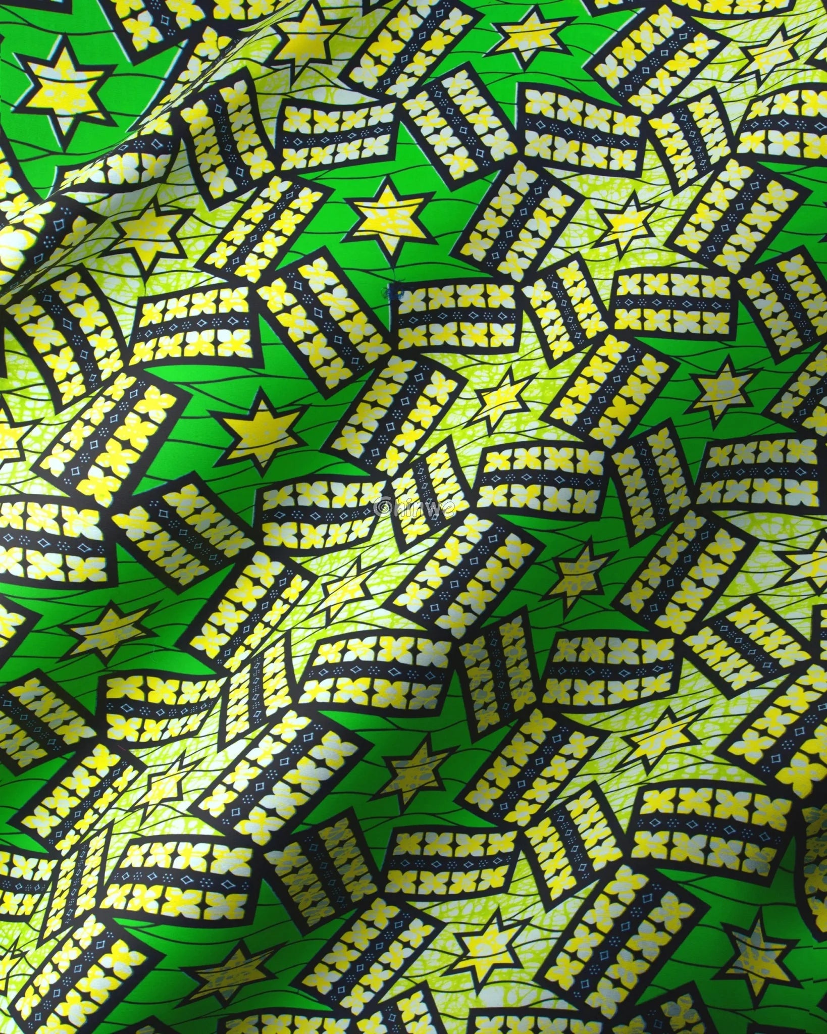 Patterned fabric with stars and zigzag designs on a green background