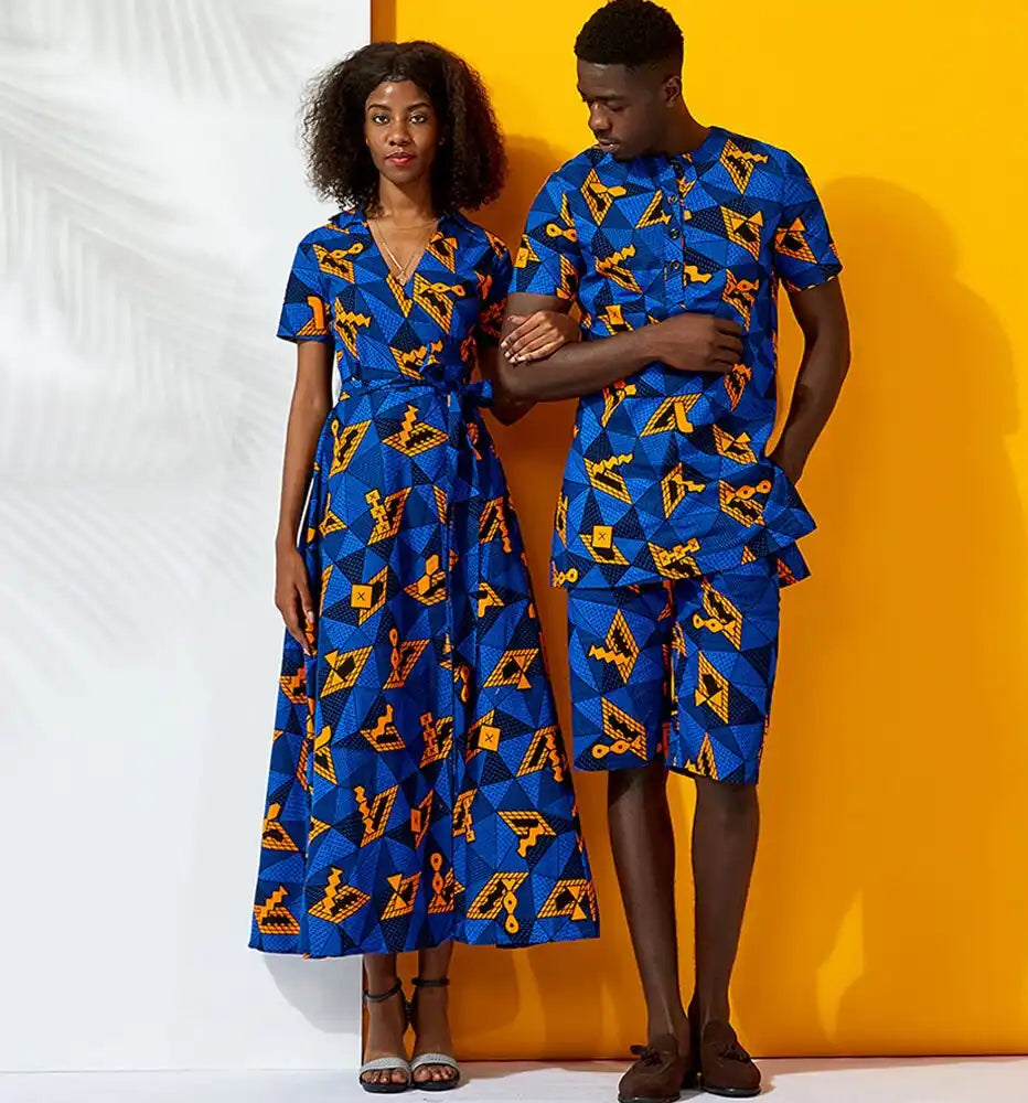 Two people wearing matching blue and yellow patterned outfits against a white and orange background