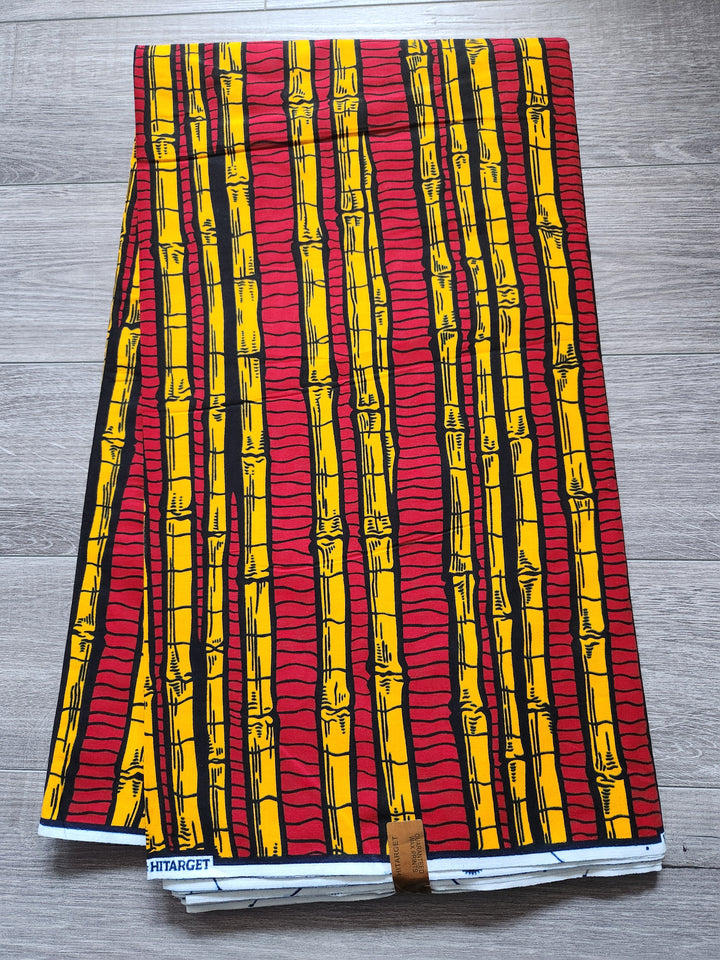 Red and yellow bamboo stripe Ankara on a wood floor